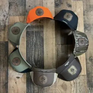 Eight caps arranged in a circle on a wooden floor.