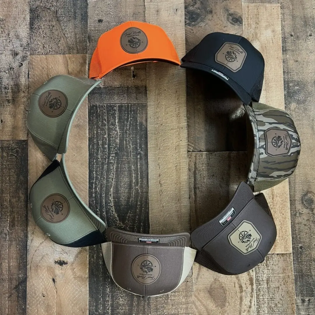 Eight caps arranged in a circle on a wooden floor.