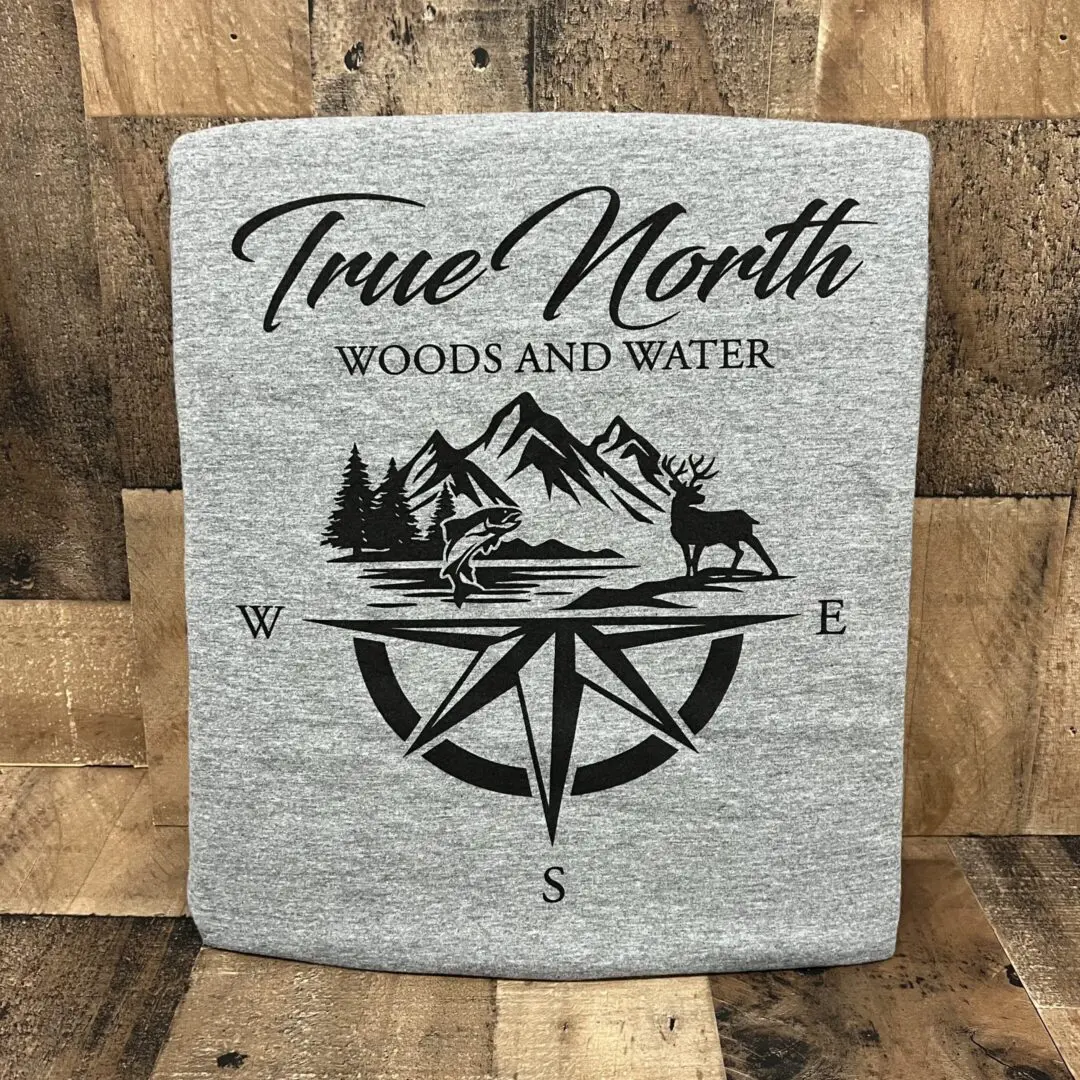 Gray sweatshirt with a compass and nature design labeled 'True North Woods and Water'.