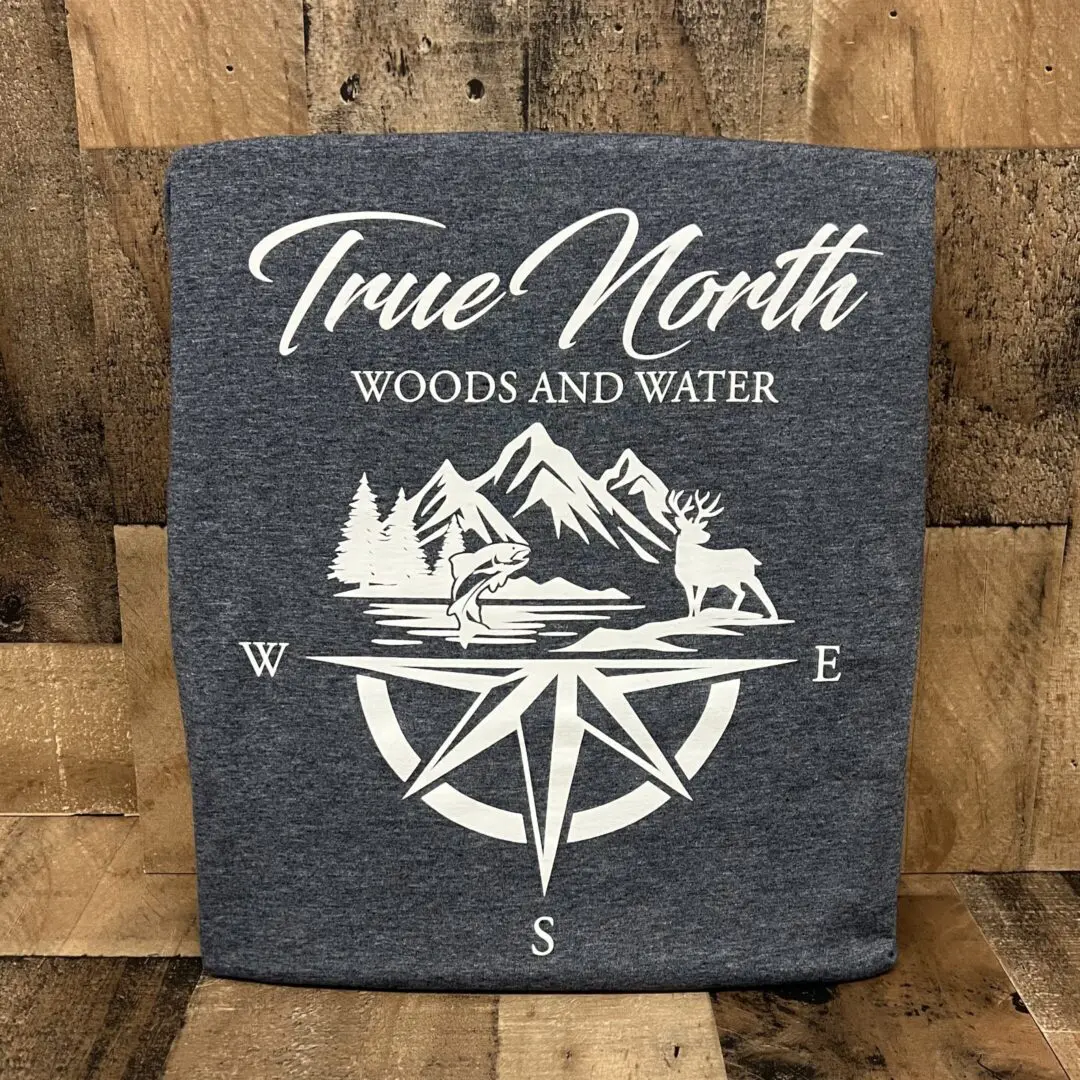Rustic wooden sign with compass and mountain design.