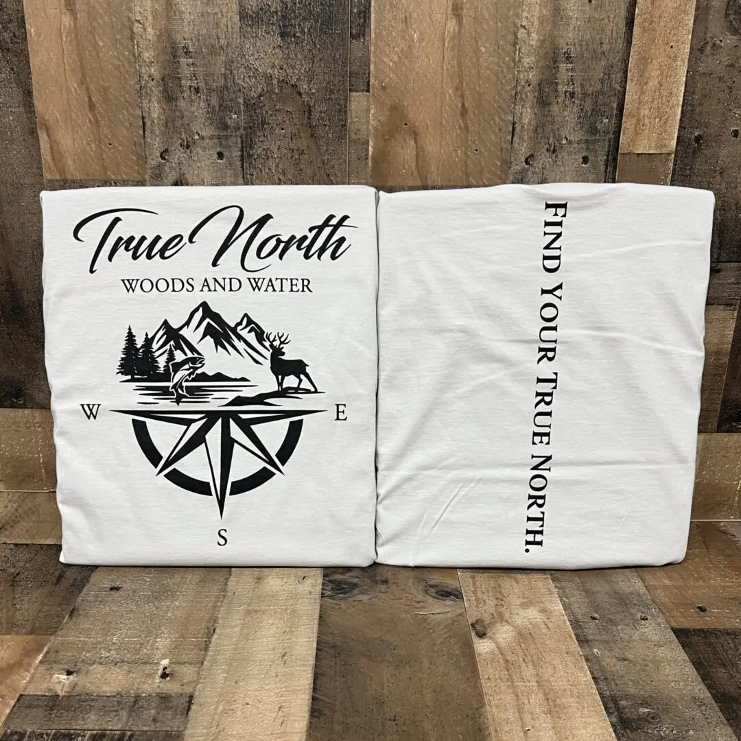 Two white cloth bags with a True North compass and mountain design.